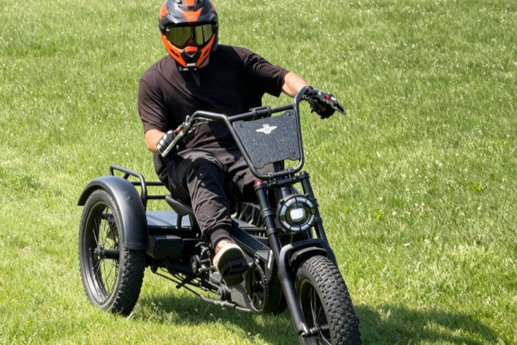 Adult rider on an electric trike for adults driving on grass