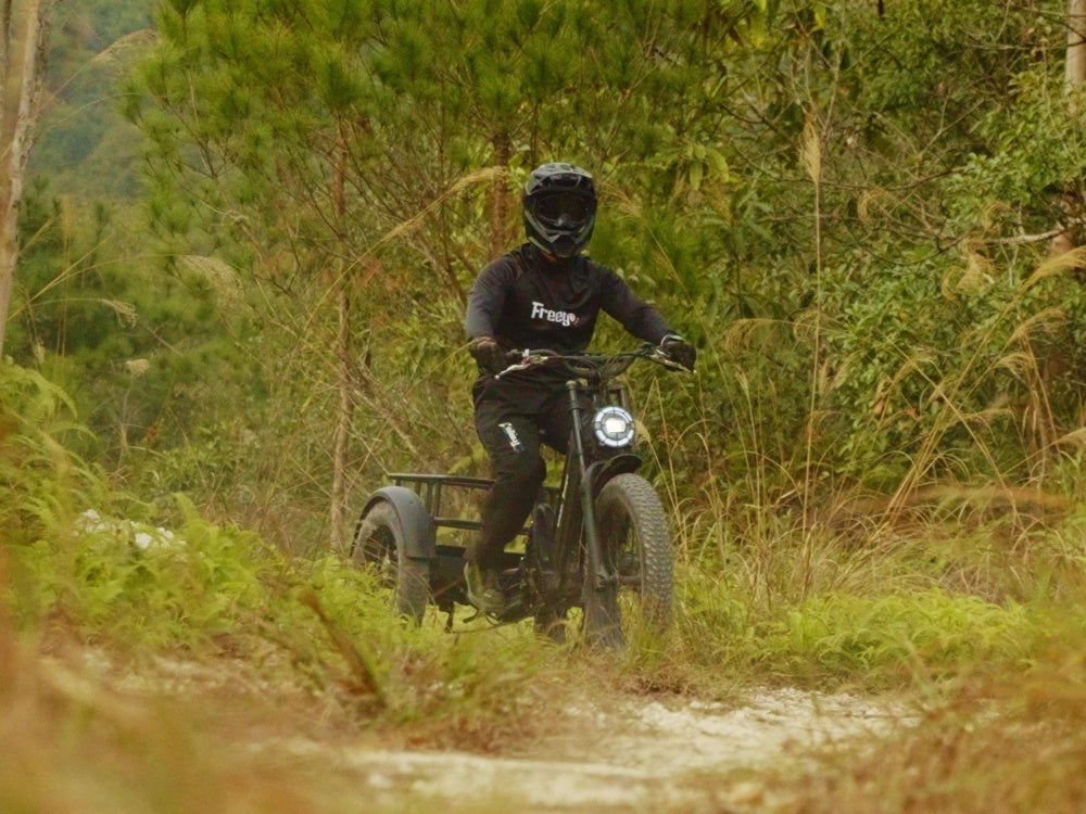 Person riding a flektrike swing through a forested area