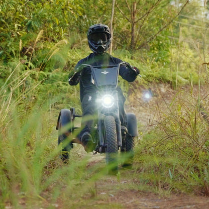 Person riding a freego flextrike pro on a dirt path surrounded by greenery