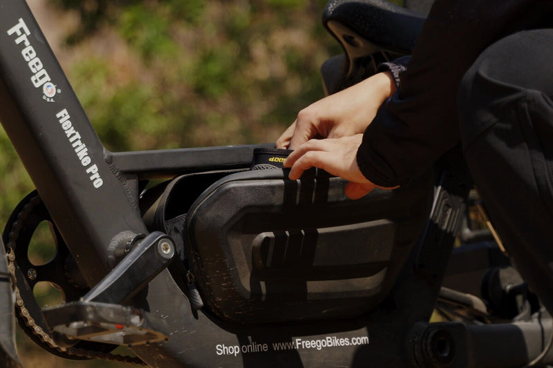 Person putting things into a storage bag on a freego flextrike pro with a blurred natural background